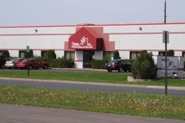 Outside photo of Springs Inc warehouse building with cars parked in front of building
